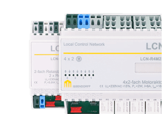 Zbliżenie na dwa moduły sterujące LCN w białych obudowach z oznaczeniami technicznymi i kolorowymi złączami.